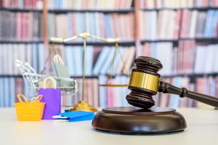 Consumer protection law, rights and guarantees, justice concept : Judge gavel, balance scale, bags, a shopping cart, depicting a safeguard designed to protect buyers from fraudulent business practices
