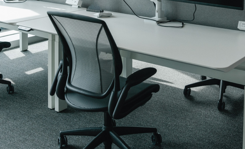 a modern, open-plan office space filled with natural light from large windows that offer a view of the cityscape