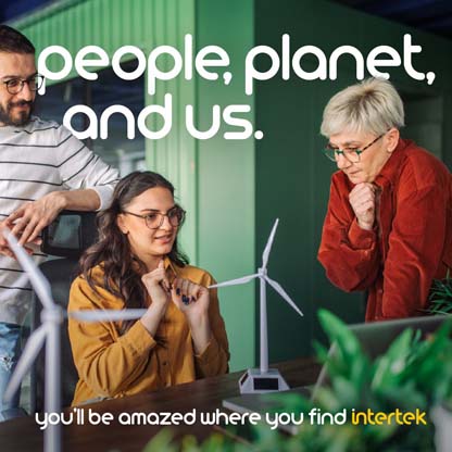 People interacting in a room with small models of wind turbines